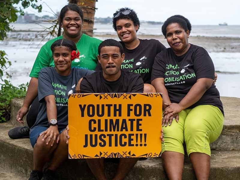 Youth with 'Youth For Climate Justice' Sign at ICJAO Event in Fiji. © Eremasi Rova / Greenpeace