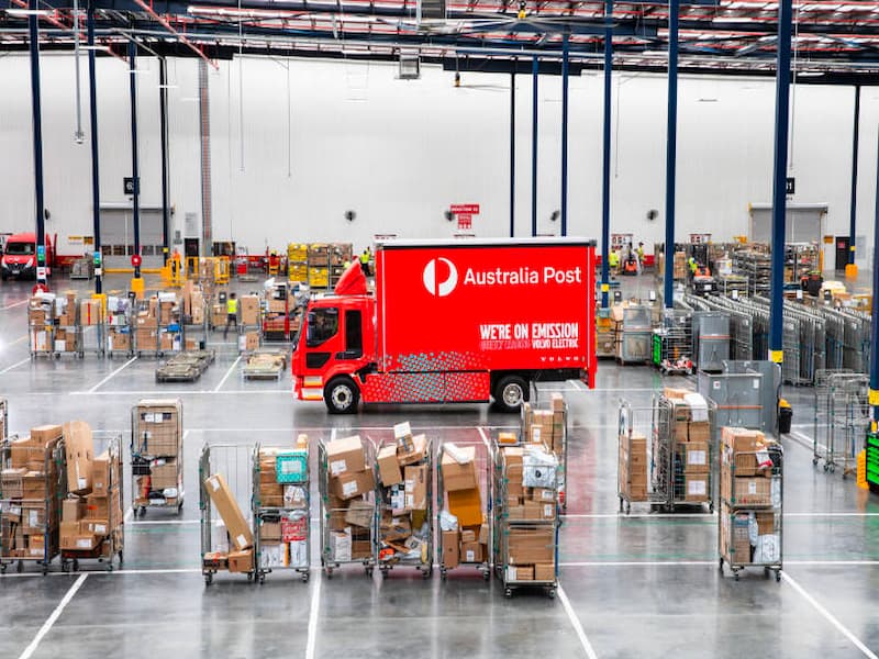 A red Australia Post electric truck in a warehouse