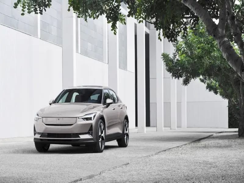 A silver Polestar car parked under a large tree